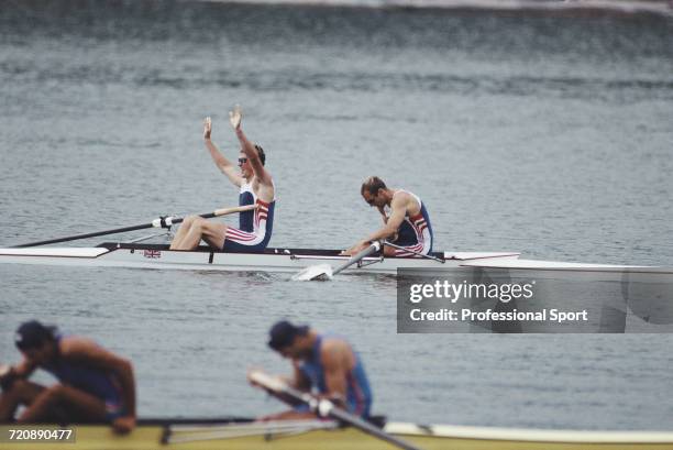 English rowers Matthew Pinsent and Steve Redgrave wave to spectators from their boat after finishing in first place for the Great Britain team to win...