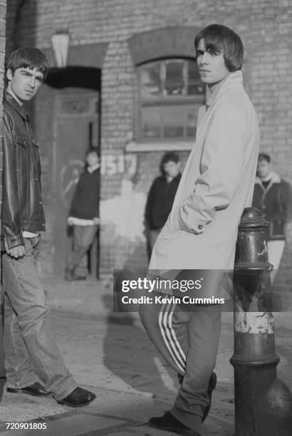 Guitarist Noel Gallagher and singer Liam Gallagher, of Manchester rock band Oasis, outside a studio on Sly Street in east London, with other band...