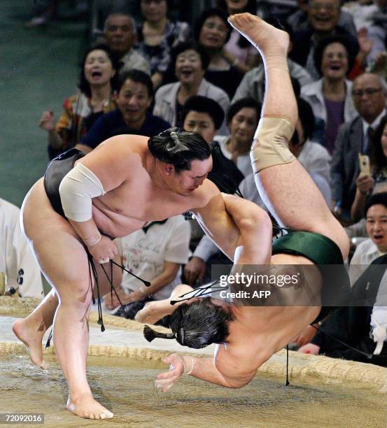 Mongolian born grand champion Yokozuna Asashoryu throws Bulgarian born champion Ozeki Kotooshu at the 12th day bout of 15-day Nagoya Grand Sumo...