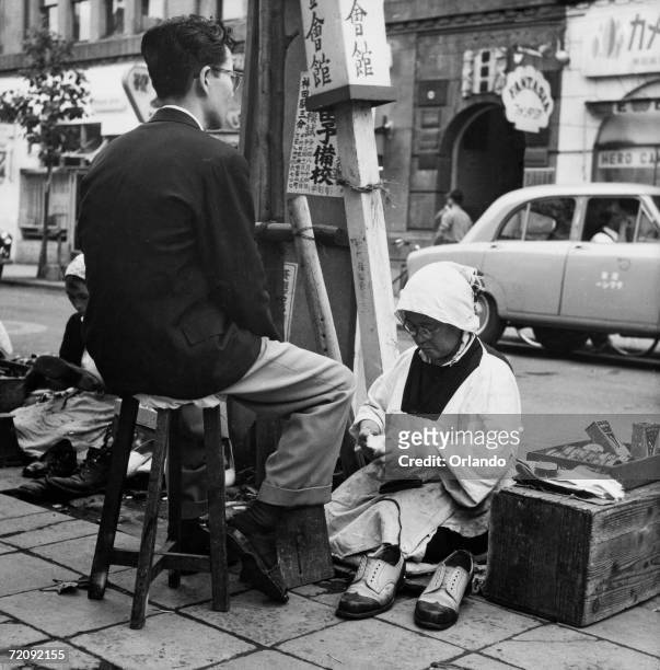 Female shoeshine in the Ginza district of Tokyo, circa 1955.