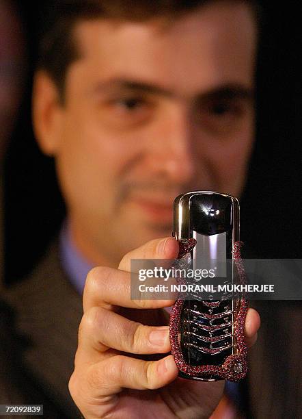 Head of Vertu, Alberto Torres - displays a Cobra mobile phone at a press conference in Mumbai, 05 October 2006. The Cobra phone, of which there are...