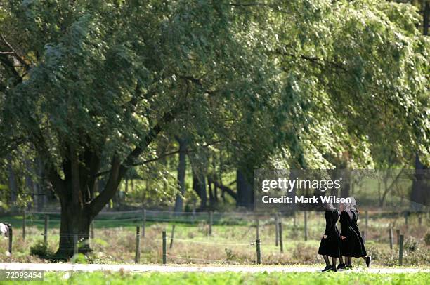 Three Amish girls walk to the Miller farm before a funeral for eight-year-old Mary Liz Miller and her sister seven-year-old Lena Miller, who were...