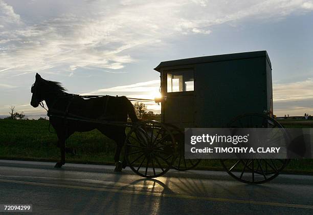 Nickel Mines, UNITED STATES: An Amish buggy makes its way down the road 05 October 2006 past the Amish School in the town of Nickel Mines where...