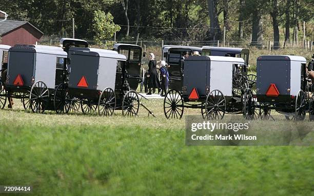Buggies are parked in the yard as members of the Amish community arrive at the Miller farm before the funeral eight-year-old Mary Liz Miller and her...