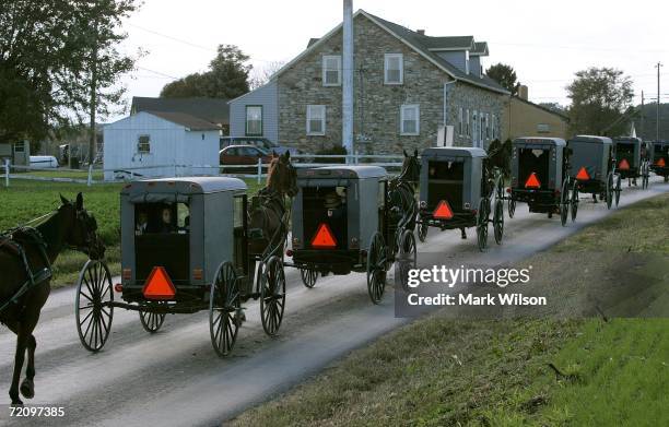 Young Amish children ride in the back of a buggy during a funeral procession for one of the Miller girls October 5, 2006 in Nickel Mines,...