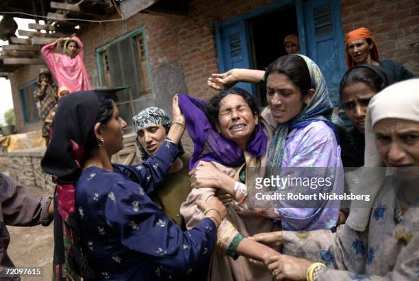 The mother of Bilal Ahmad Sheikh, one of the three Kashmiri teenagers mistakenly shot and killed by Indian Army soldiers in Villgam, weeps in a...