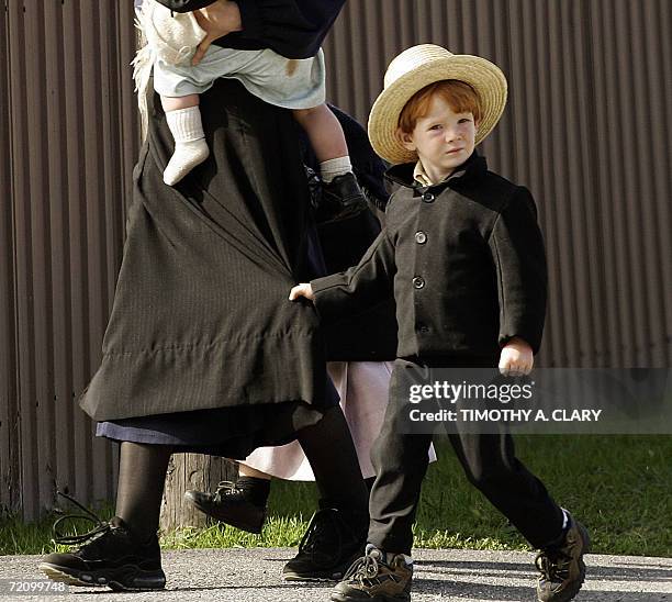Nickel Mines, UNITED STATES: An Amish family arrives in town to attend the funeral of one of the victims of the Amish school shooting makes its way...