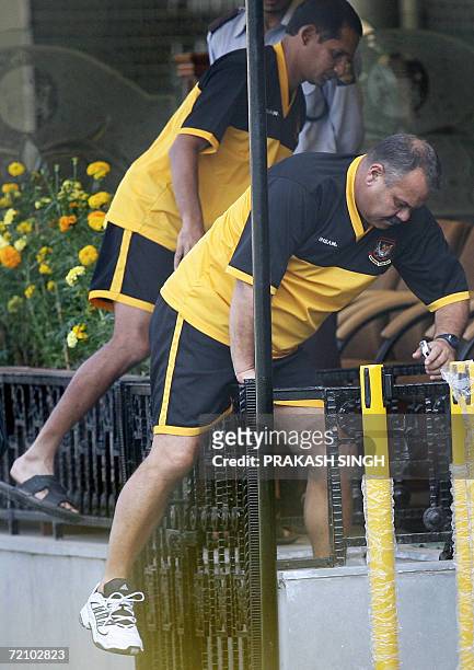 Bangladesh cricket team captain's Habibul Basher and coach Davenell Whatmore cross a railing on their way to a press conference at the Punjab Cricket...