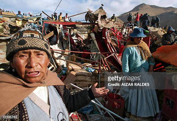 Quechuas natives women search for belongings in the rubble of their houses after clashes between state-owned tin mine and cooperative workers in...