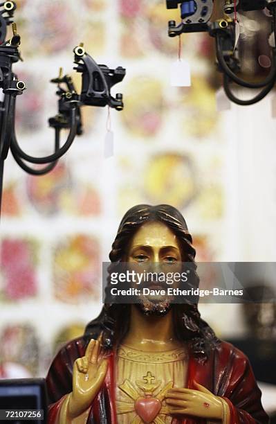 Tattoo guns are sold along side an icon of Jesus at the second British international tattoo event on October 6, 2006 at The Old Truman Brewery in...