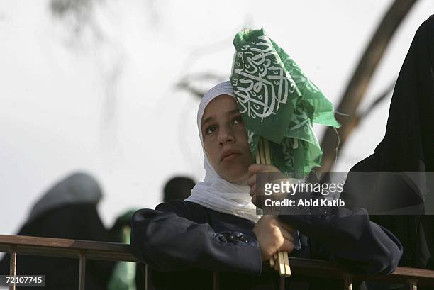 Palestinian girl holds Hamas flags as she listens to the Authority Prime Minister Ismail Haniyeh's speech in a soccer stadium on October 6, 2006 in...
