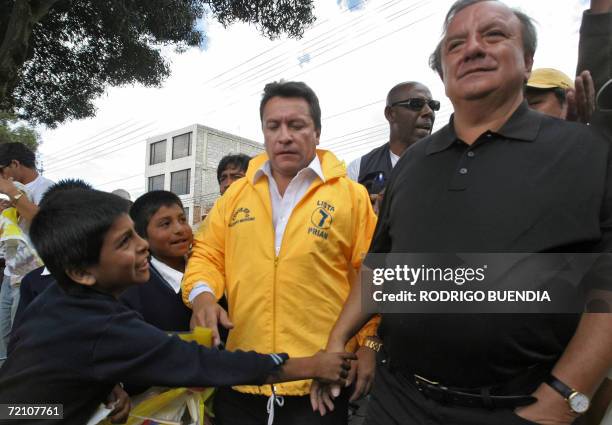 Un nino saluda a Alvaro Noboa , canditato presidencial por el Partido Renovacion Institucional de Accion Nacional , durante un recorrido por un...