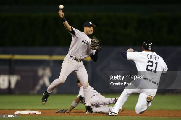 Derek Jeter of the New York Yankees unsuccessfully attempts to turn a double play after he forced out a sliding Sean Casey of the Detroit Tigers in...