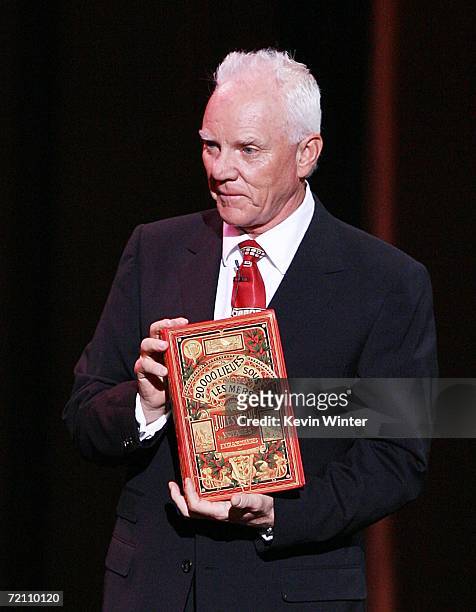 Actor Malcolm McDowell holds an original first edition of Jules Verne's "20,000 Leagues Under the Sea" at the Jules Verne Adventure Film Festival at...