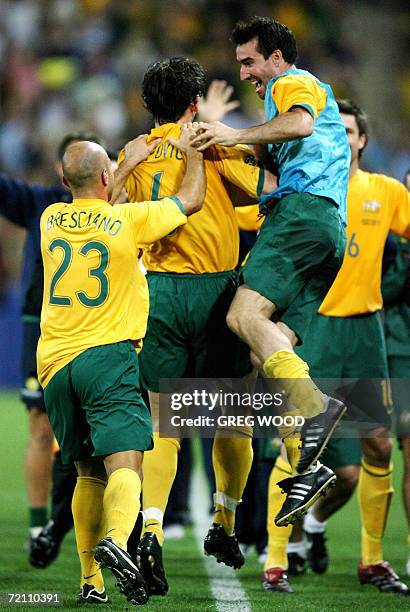 Australia's Tony Popovic is mobbed by teammates Tony Vidmar and Mark Bresciano after scoring a goal in the football friendly against Paraguay in...