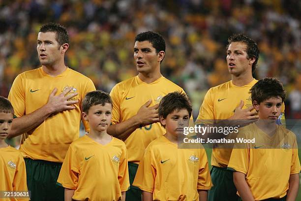 Lucas Neill, John Aloisi and Brett Emerton of Australia sing the national anthem during the international friendly match between Australia and...