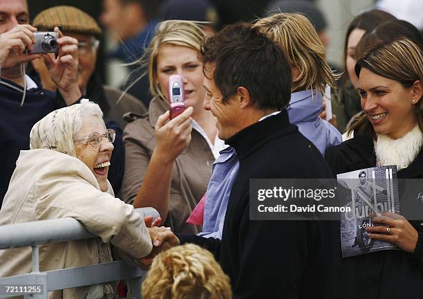 Actor Hugh Grant greets at fan at the 18th hole during the Third Round of The Alfred Dunhill Links Championship at Carnoustie Golf Club on October 7,...