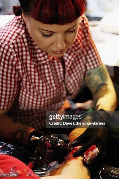 Tattoo artist works during day two of the second British international tattoo event on October 7, 2006 at The Old Truman Brewery in Brick Lane,...
