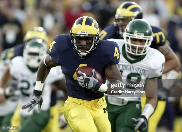 Brandon Minor of Michigan runs to the end zone past Justin Kershaw of Michigan State to score a 40 yard touchdown run for a 31-7 lead during the...