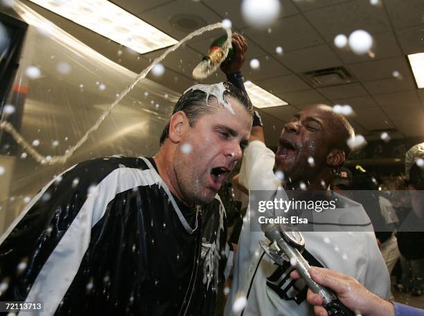 Kenny Rogers of the Detroit Tigers is sprayed with doused with champange by teammate Craig Monroe in the locker room as the Tigers celebrate their...