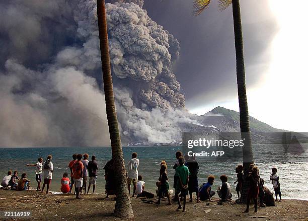 Rabaul, PAPUA NEW GUINEA: Evacuated Matapit Islanders watch Tavurvur volcano erupt sending ash and rocks over the already devastated city of Rabaul...