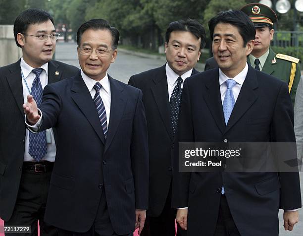 Chinese Premier Wen Jiabao shows the way to new Japanese Prime Minister Shinzo Abe during a welcoming ceremony outside the Great Hall of the People...