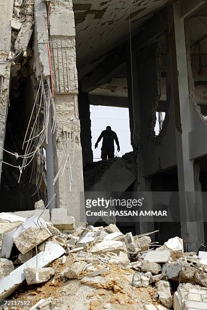 Lebanese man is silhouetted among the wreckage of a mosque destroyed by an airstrike, in the southern Lebanese town of Khiam, near the Israeli...