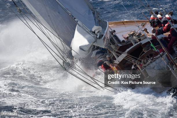 Large wave rushes down the deck of the famous J-Class yacht Shamrock V washing over the crew as the yacht close reaches in a Mistral wind whilst...