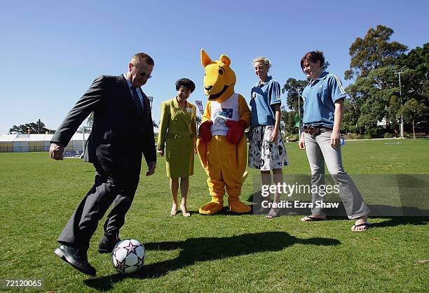 Australian Olympic Committee President John Coates kicks the soccer ball around as Le Lam, Mayor of Auburn Council, a boxing kangaroo and athletes...