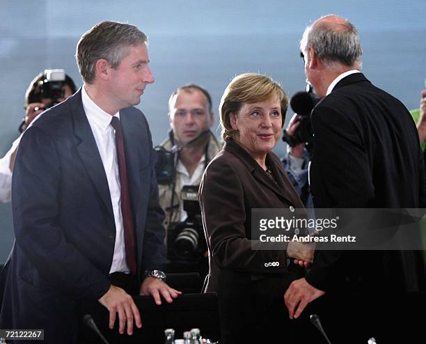 German Chancellor Angela Merkel shakes hands with Dieter Zetsche , chairman of DaimlerChrysler AG as Klaus Kleinfeld , President and CEO of Siemens...