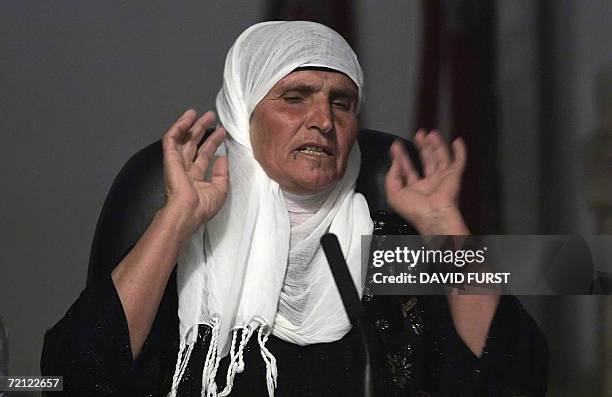 Witness, whose name was withheld by court officials, gestures as she testifies against Iraqi leader Saddam Hussein and six co-defendants during their...