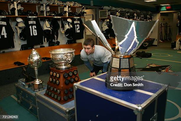 Josh Gorges of the San Jose Sharks skates looks over off season trophies won by Sharks players from last season in the locker room prior to a game...