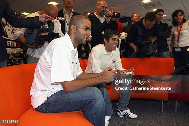 Tony Parker of the San Antonio Spurs and Lyon's Brazilian soccer midfielder Juninho play video games during an EA appearance for the NBA Europe Live...