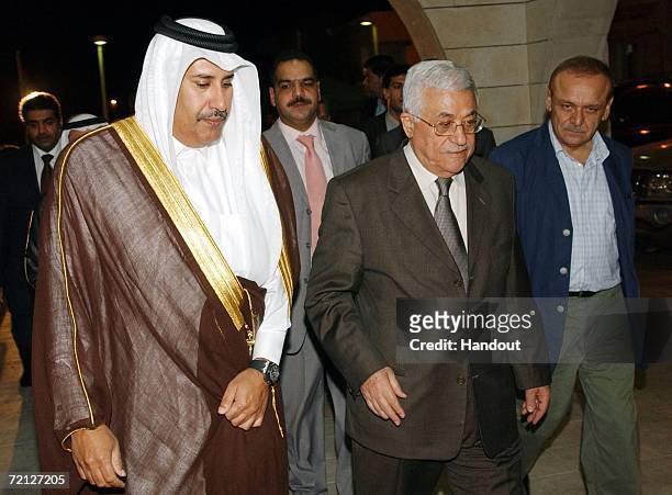 In this handout provided by the Palestinian Press Office Qatar's Foreign Minister Sheikh Hamad bin Jassim al-Thani walks with Palestinian Authority...