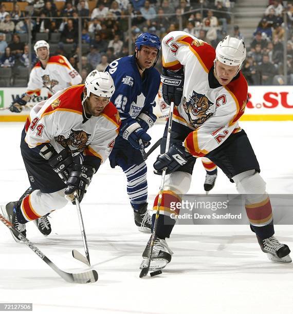 Todd Bertuzzi of the Florida Panthers is tripped up by Kyle Wellwood of the Toronto Maple Leafs as Olli Jokinen of the Florida Panthers caries the...