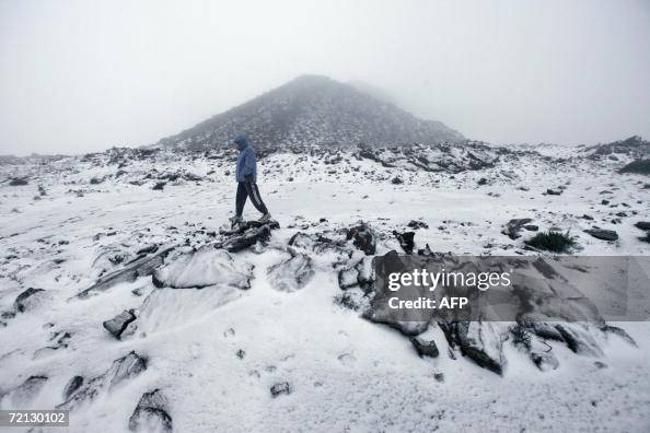 A person walks in snow near the summit A person walks in snow near the summit