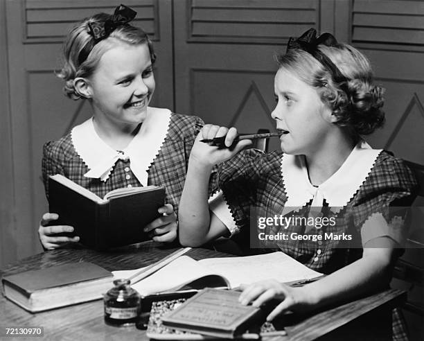 two girls (10-11) doing homework (b&w) - young girls homework stockfoto's en -beelden