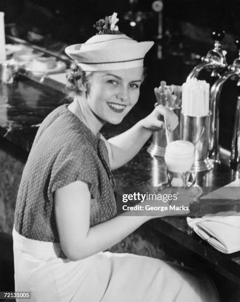 young woman in fancy hat drinking ice cream soda (b&w), portrait - soda fountain stock pictures, royalty-free photos & images