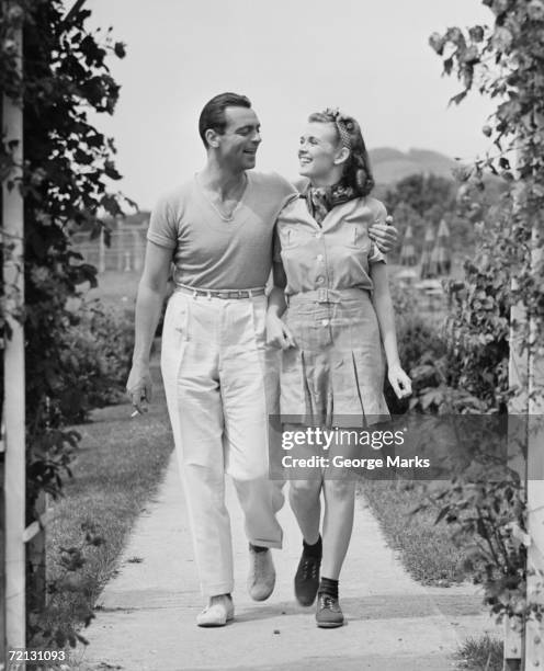 couple walking on footpath (b&w) - 1950s couple stock pictures, royalty-free photos & images