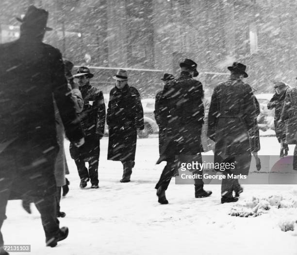 people walking on street in snowstorm - overcoat stock pictures, royalty-free photos & images