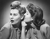 Two women gossiping in studio (B&W)