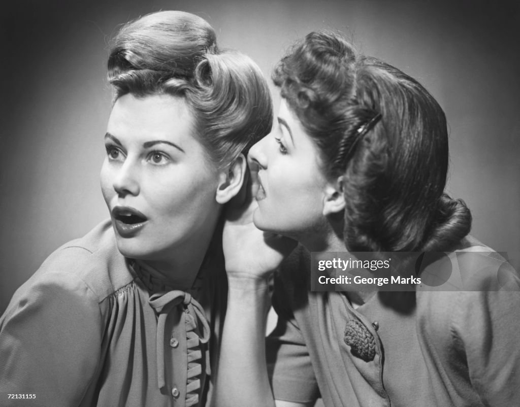 Two women gossiping in studio (B&W)