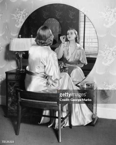 woman applying make up in front of vanity table,  (b&w), - 1940s bedroom stock pictures, royalty-free photos & images