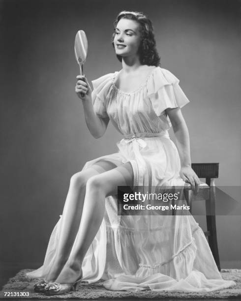 woman looking at hand mirror (b&w) - vintage 1950s woman stock pictures, royalty-free photos & images