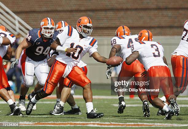 Quarterback Perry Patterson Jr. #10 of the Syracuse Orangemen hands-off the ball to Delone Carter against the Illinois Fighting Illini on September...