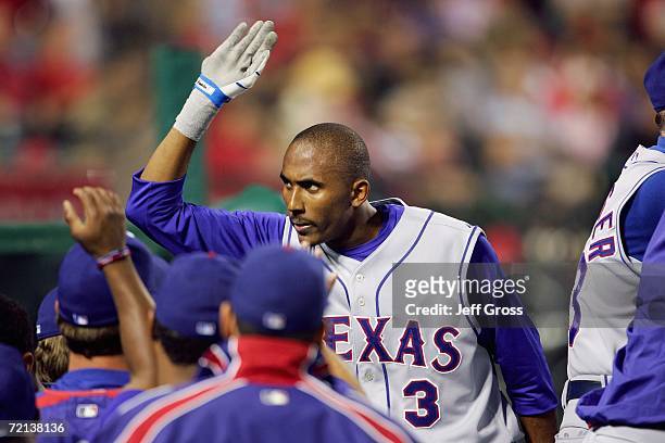 Joaquin Arias of the Texas Rangers gives high fives after a play against the Los Angeles Angels of Anaheim at Angel Stadium during the game on...