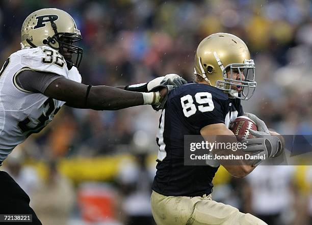 Tight end John Carlson of the Notre Dame Fighting Irish attempts to break away from linebacker Cliff Avril of the Purdue Boilermakers September 30,...
