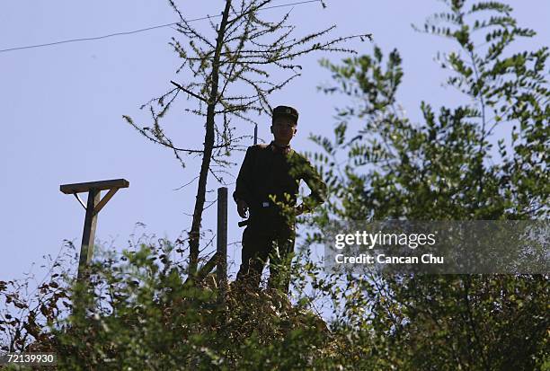 North Korean soldier stands guard on the banks of the Yalu River, opposite the Chinese border city of Dandong October 11, 2006 in Uiju, Democratic...