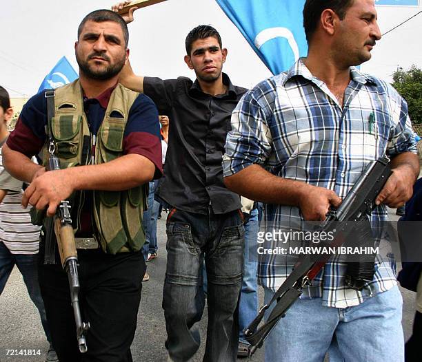 Iraqi Turkmen carry machine guns as they demonstrate in the oil-rich city of Kirkuk to protest against federalism and to insist on the Iraqi identity...