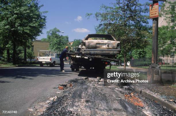 Burnt-out car is taken away in the aftermath of the 1992 Los Angeles riots, which followed the beating of black motorist Rodney King by members of...